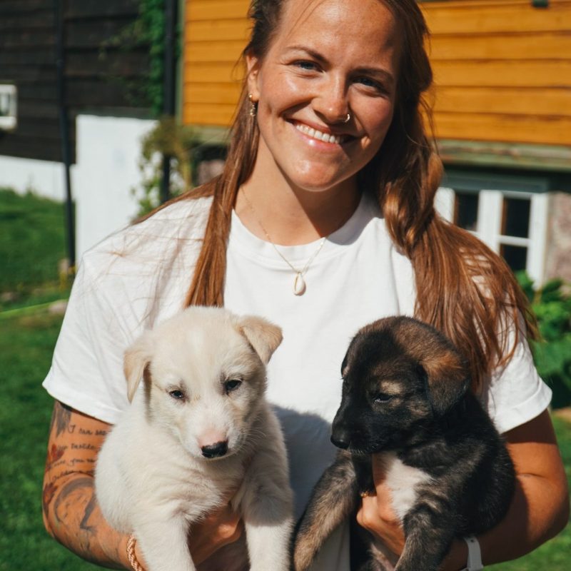 a woman holding two dogs