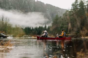 two people riding a canoe on the river