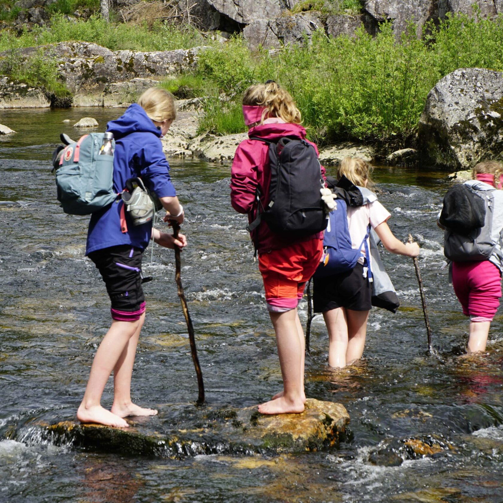 a group of people crossing a river