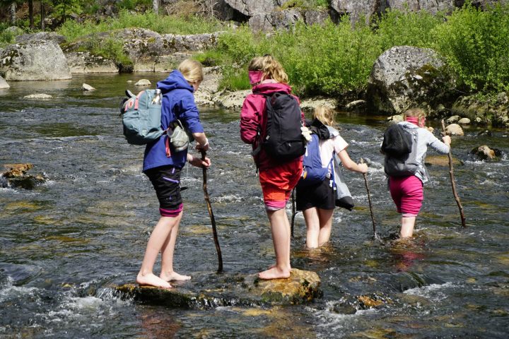 a group of people crossing a river