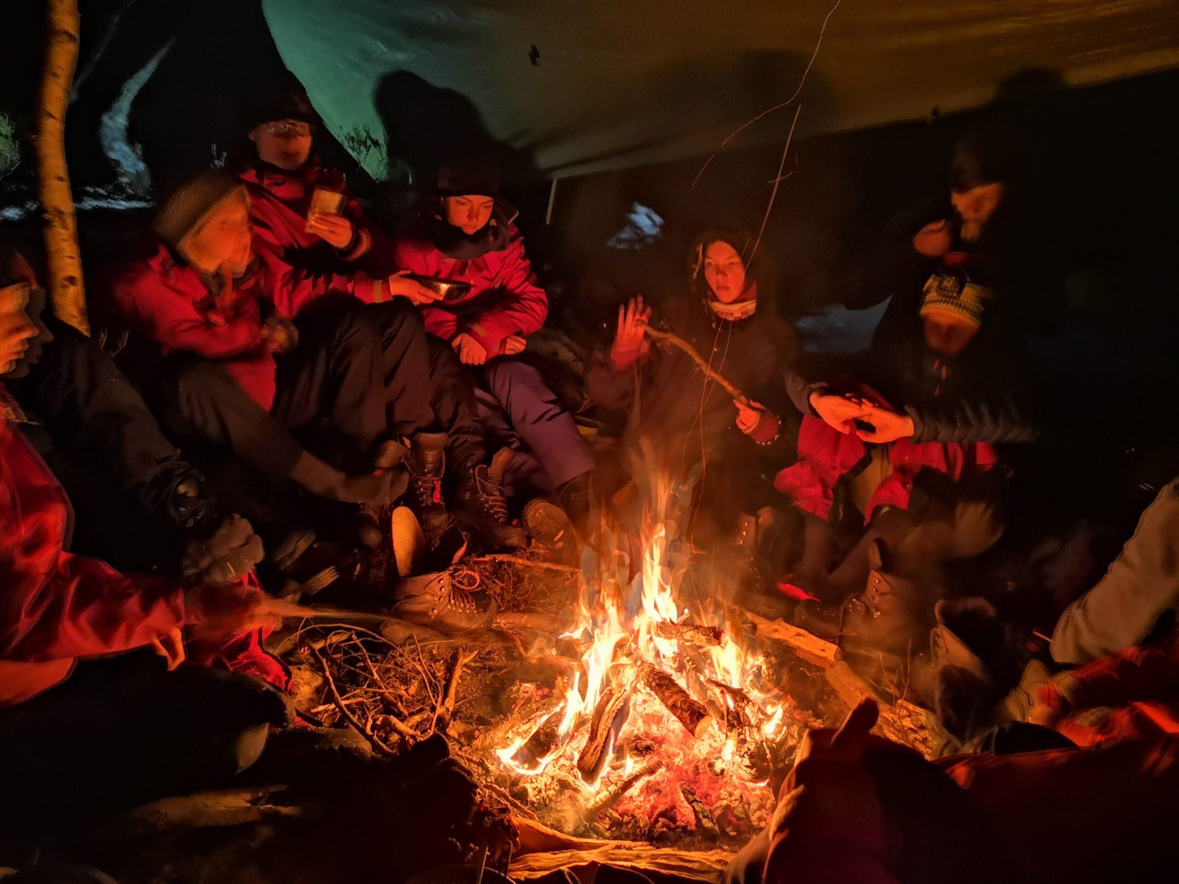 a group of people sitting around a fire