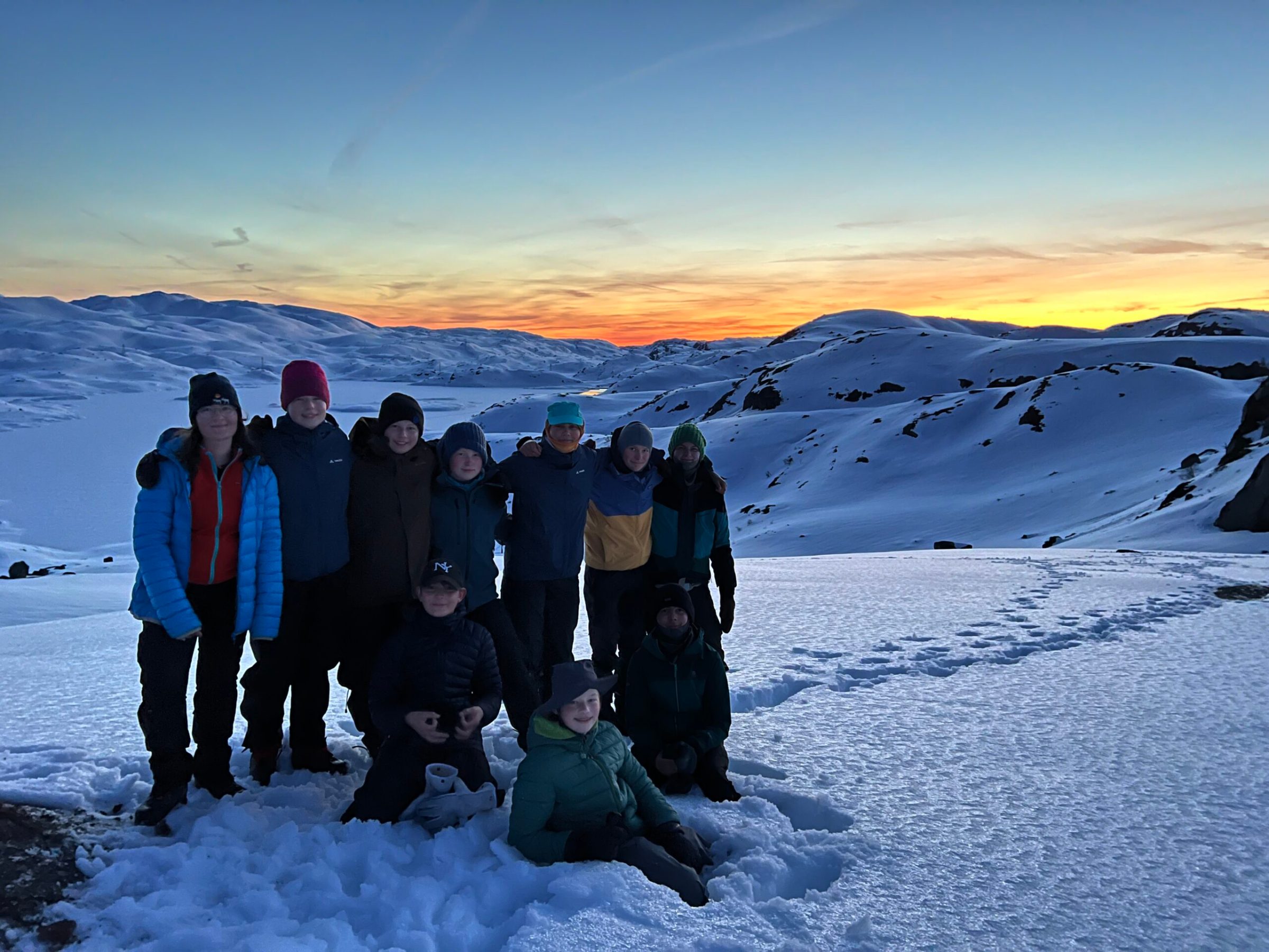 a group of people standing in the snow