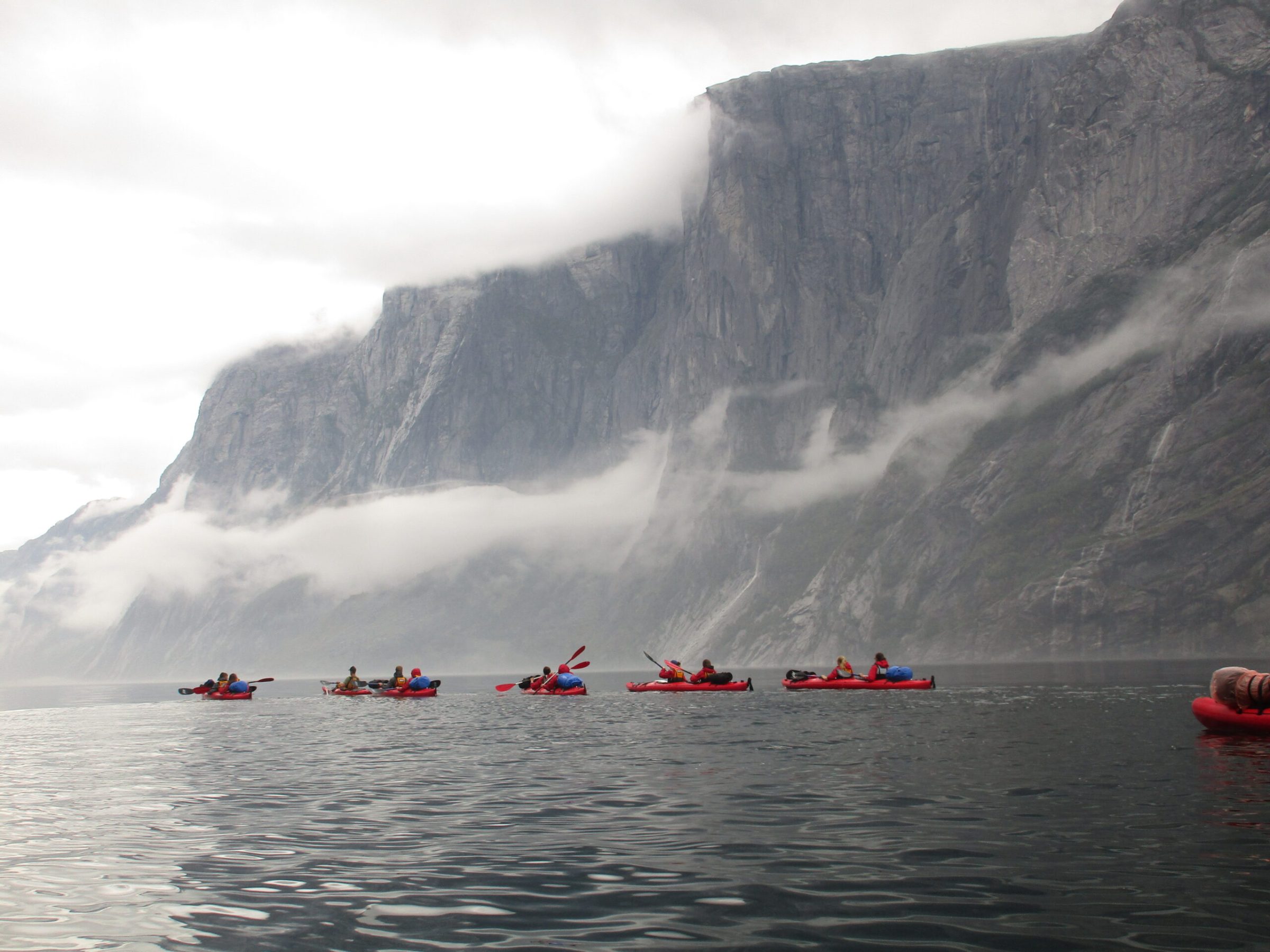 a group of people in a small boat in a body of water