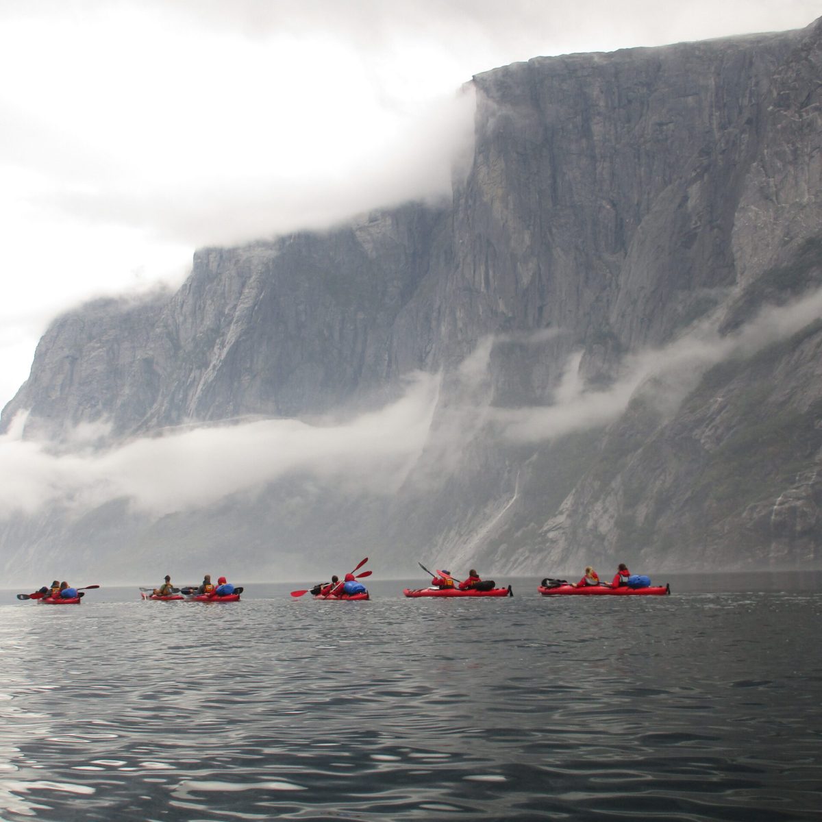 a group of people in a small boat in a body of water